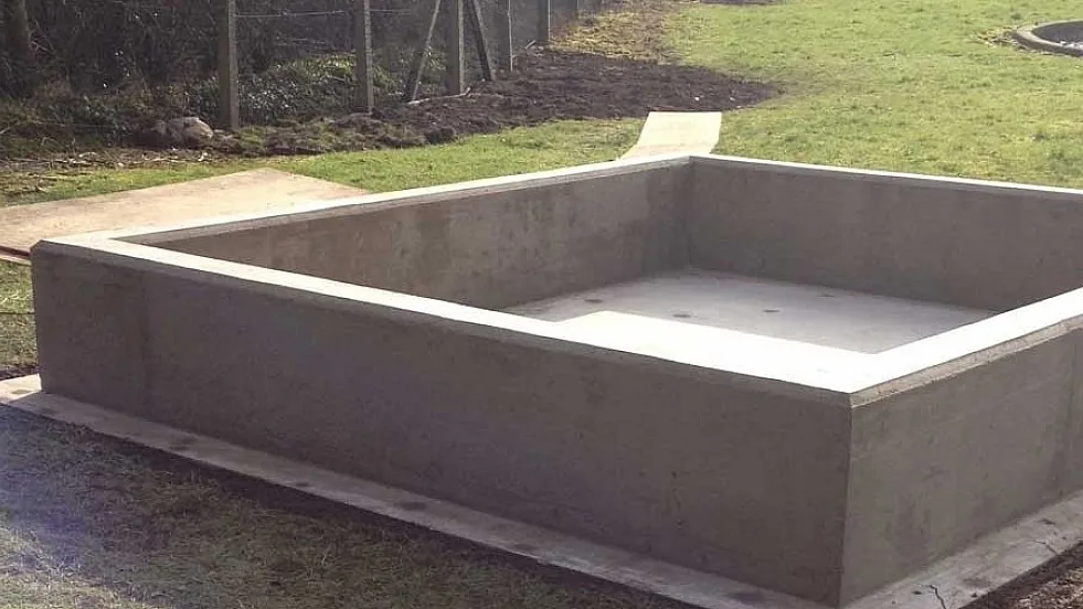 Prázdny obdĺžnikový betónový záchyt s vyvýšenými stenami.